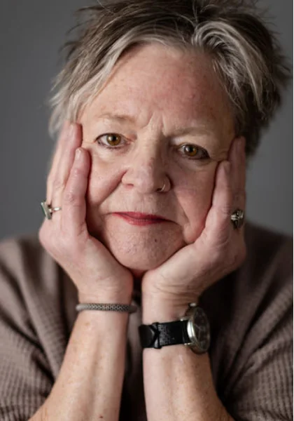 Jo Hart resting her chin in her hands, looking toward the camera.